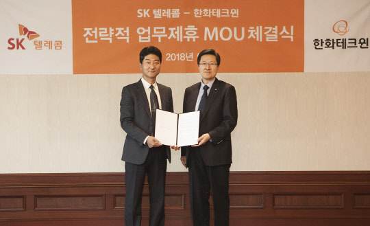 정순구 SK텔레콤 시큐리티유닛장(왼쪽)과 안순홍 한화테크윈 마케팅실장이 업무협약 후 기념촬영을 하고 있다.  SK텔레콤 제공